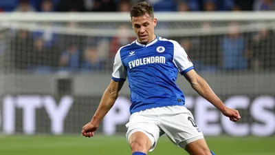 A photorealistic image of an anonymous 25-year-old FC Volendam player with a rugged build, wearing a blue jersey with...