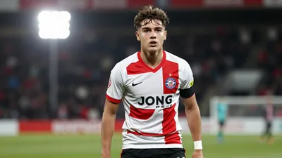 A photorealistic image of a 21-year-old midfielder with a messy haircut, wearing a Jong PSV jersey with a white and red...