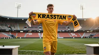 Kayne van Oevelen, 22, in a plain orange goalkeeper jersey and black shorts, crouched on a rain-slicked pitch, gloves...